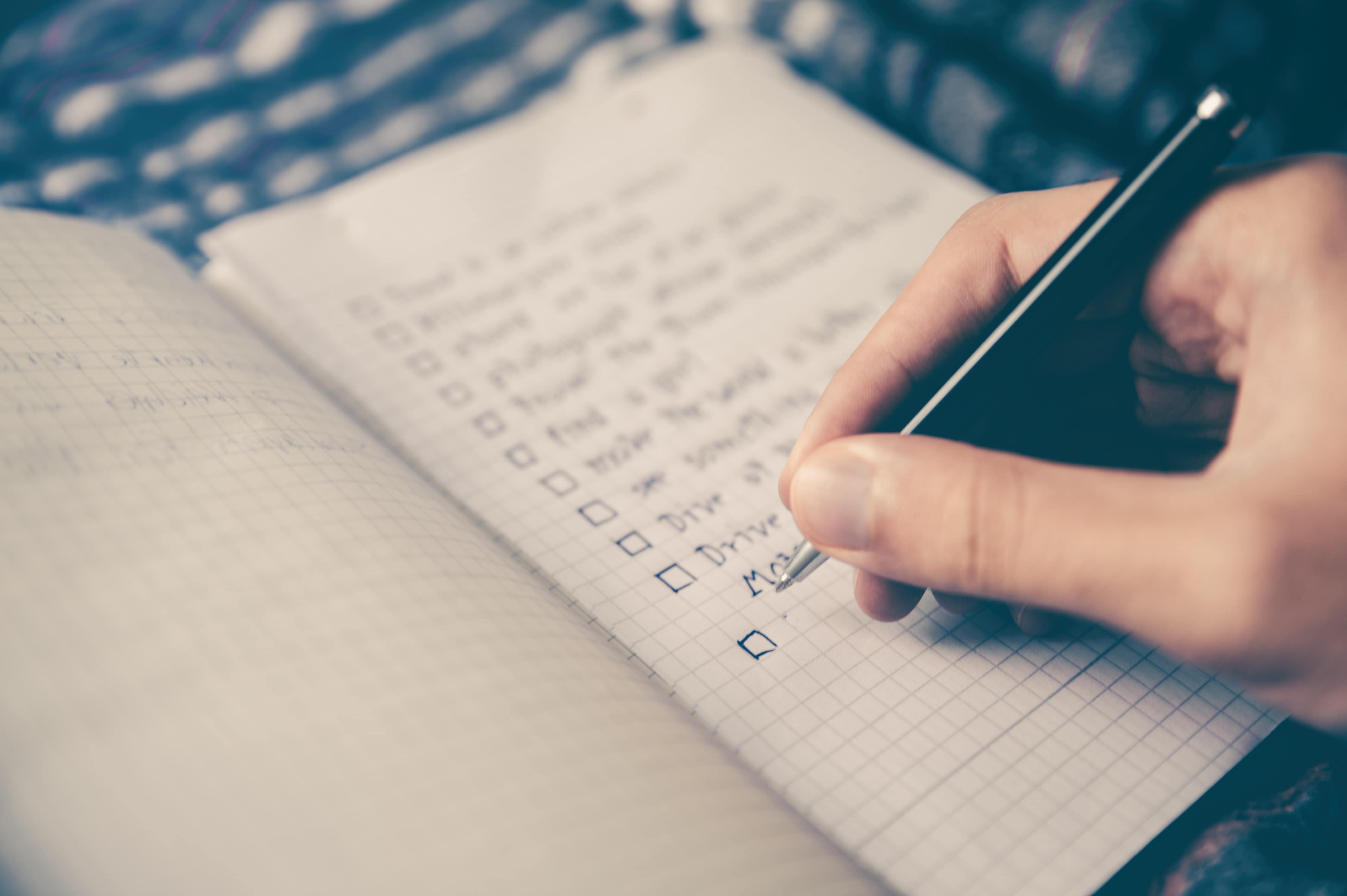 Woman's hand prioritizing a list of items