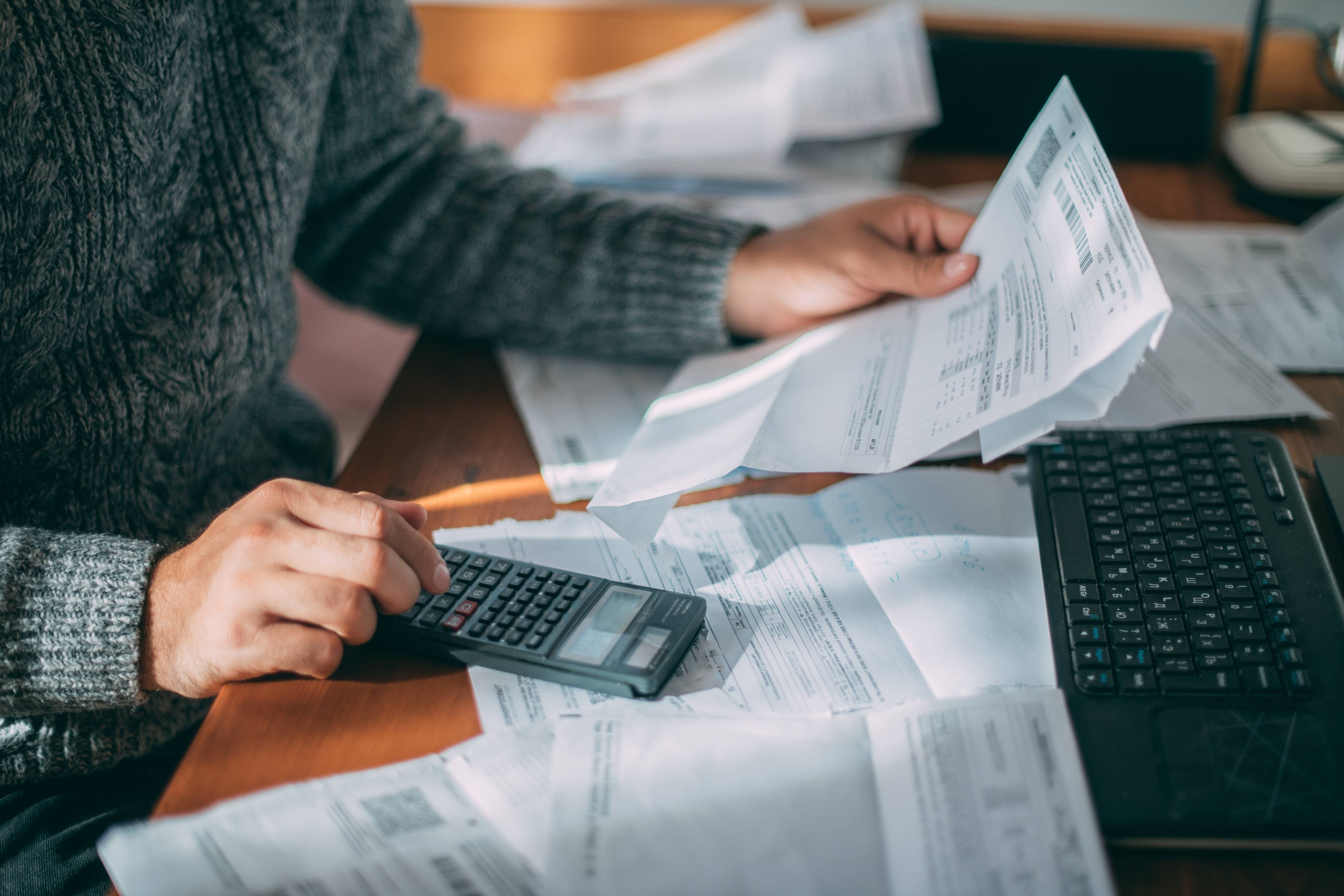 Man holding bills and working with calculator
